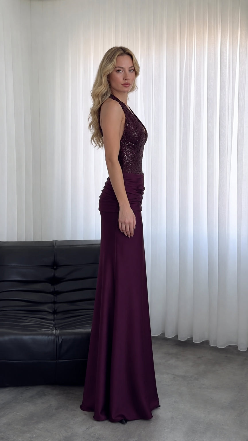 Side profile view of model wearing Burgundy sequin bodice formal gown