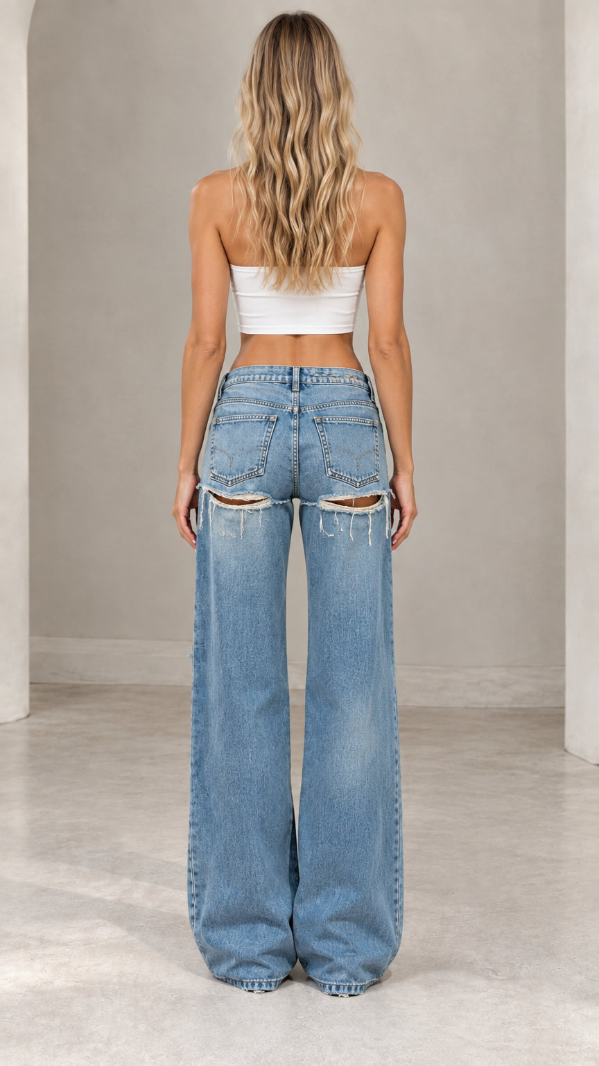 Back view of women's wide-leg denim jeans showing back pocket cutout distressing