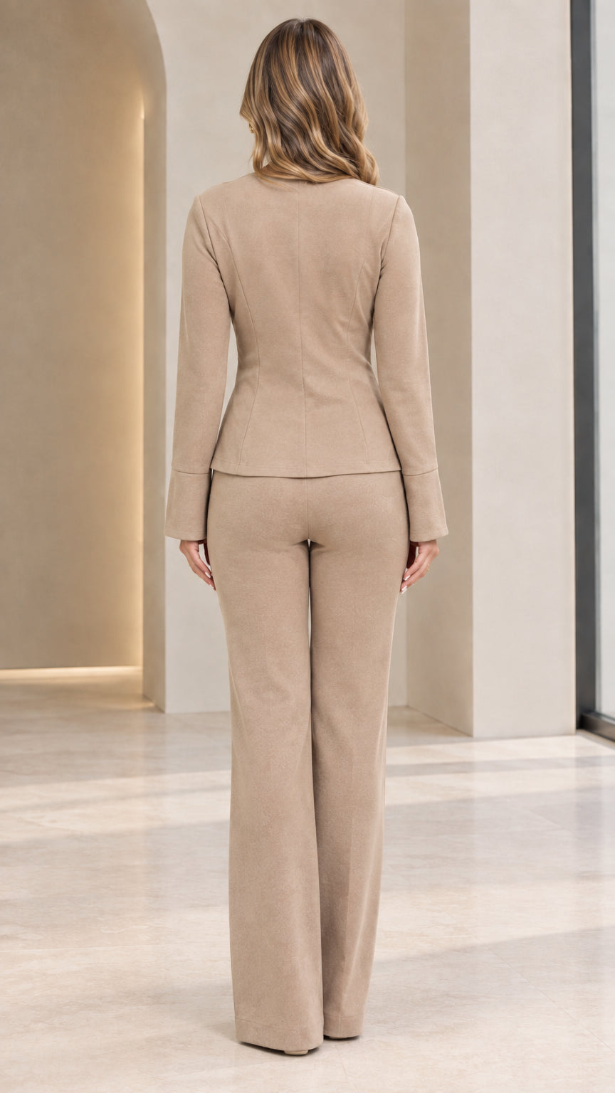 Back view of woman wearing beige long sleeve top and flare trousers set
